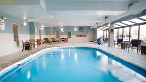 Una piscina interior con sillones de descanso y una estación de salvavidas.