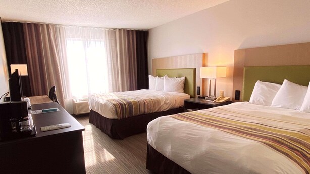 A hotel room with two beds, a desk with a coffee maker, and a lamp. - Country Inn & Suites by Radisson, Elk River, MN (Elk River)