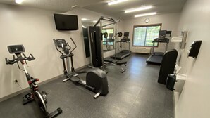 A gym with cardio machines, weightlifting equipment, and a mirrored wall. - Country Inn & Suites by Radisson, Elk River, MN (Elk River)