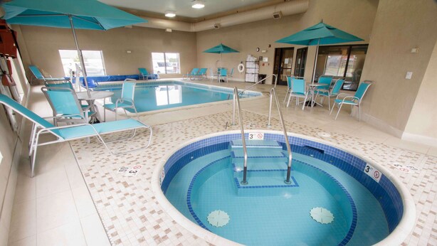 Una piscina interior con varias pistas de natación, tumbonas y sombrillas.