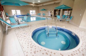 Une piscine intérieure dotée de plusieurs couloirs de nage, de chaises longues et de parasols.