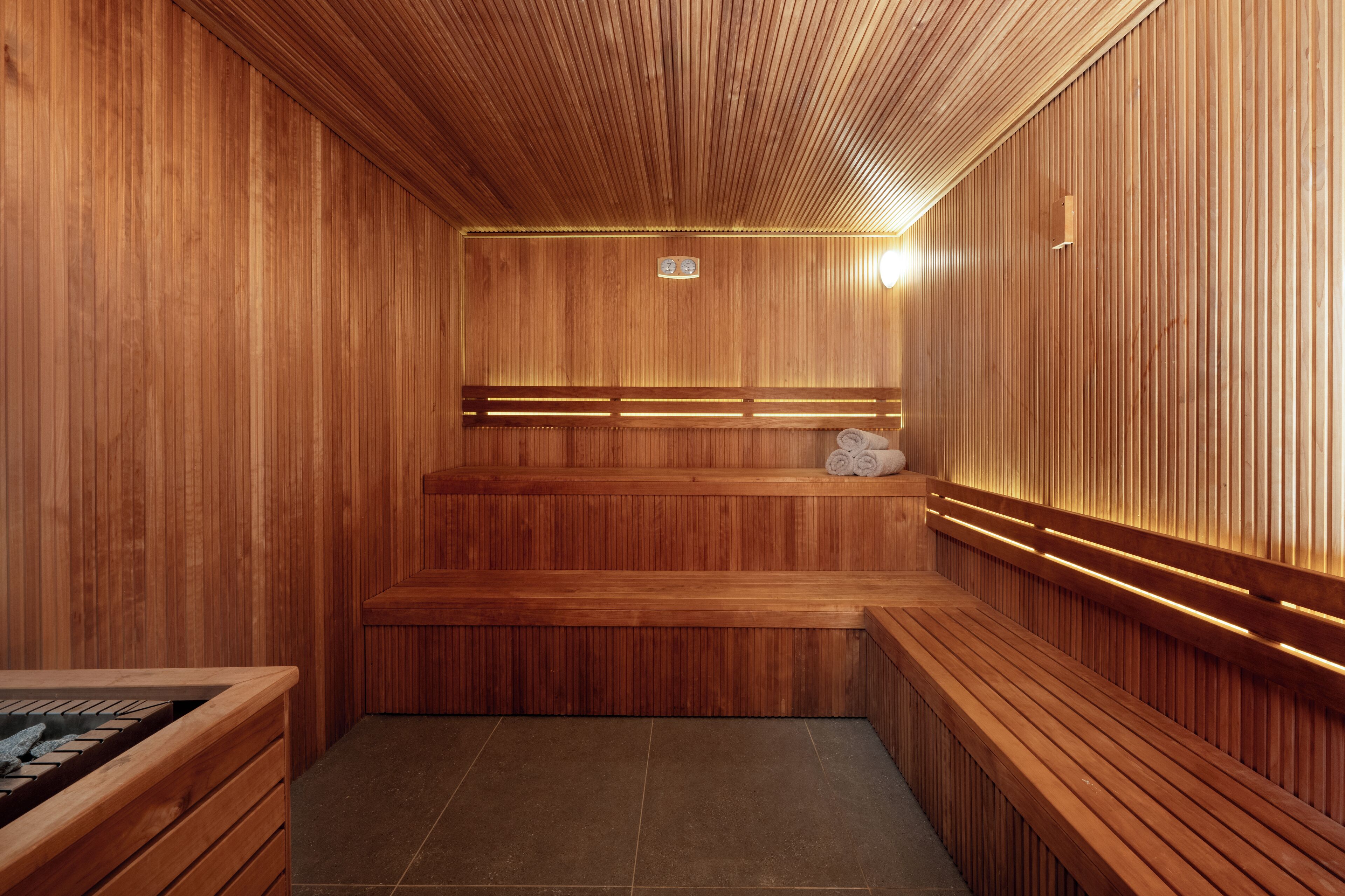 A wooden sauna with benches and a bench with a towel.