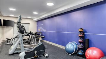 A gym with treadmills, a stationary bike, and various exercise balls.