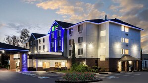 A hotel with a modern design, featuring a prominent entrance, a landscaped garden, and a parking area. - Holiday Inn Express Hotel & Suites Portland-Jantzen Beach by IHG (Portland)