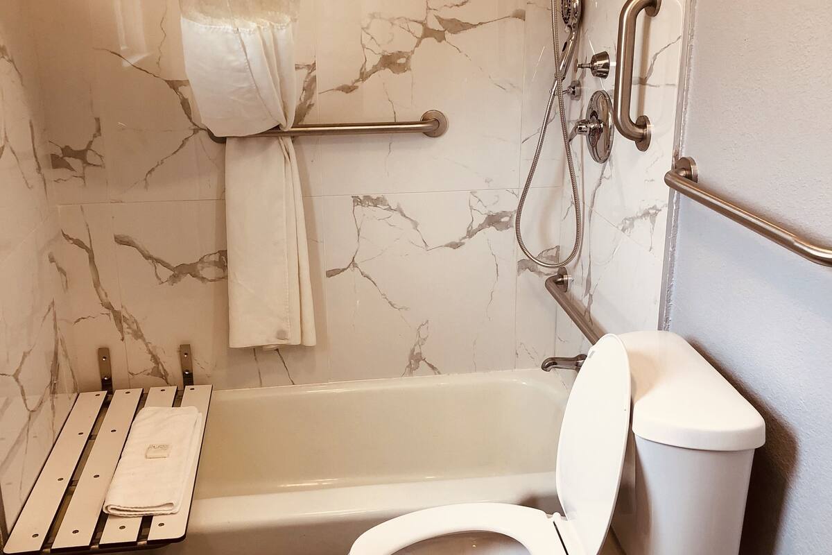 A bathroom with a bathtub, toilet, and shower.