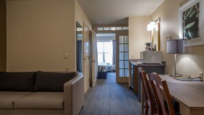 A compact hotel room with a kitchenette, a dining area, a sofa, and a bed. - Country Inn & Suites by Radisson, Milwaukee Airport, WI (Milwaukee)