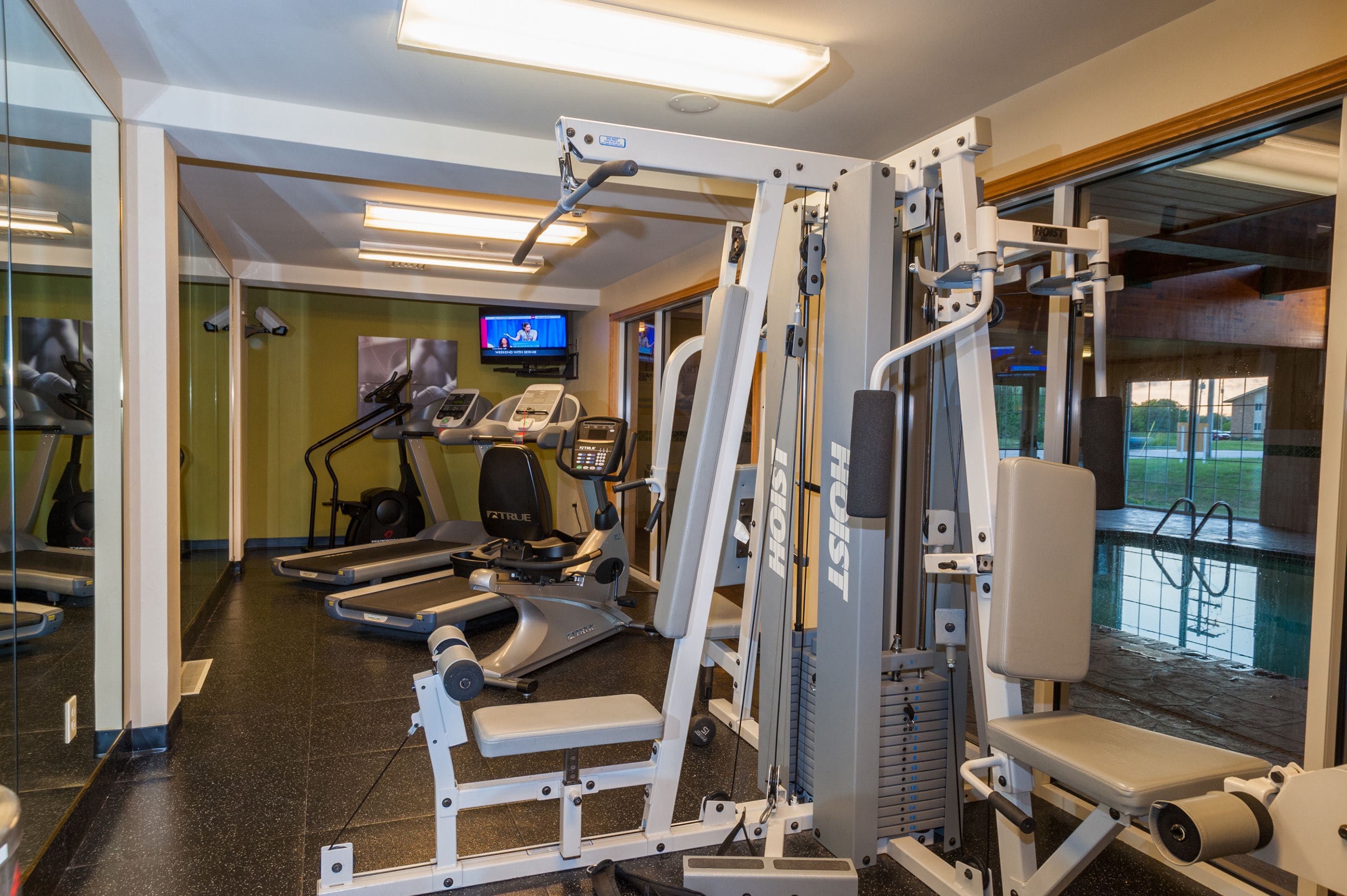 Een sportschool met loopbanden, elliptische trainers en gewichten.