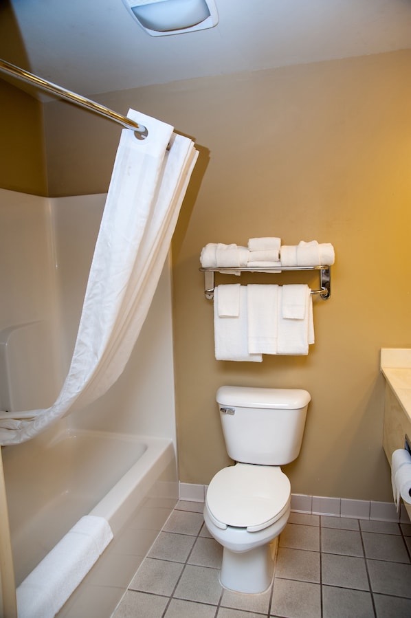 A bathroom with a bathtub, toilet, and towel rack.