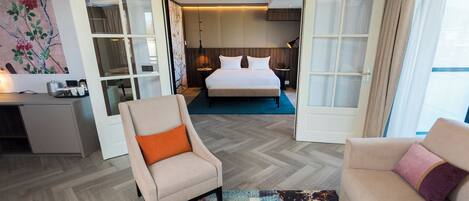 Una habitación de hotel con una cama, un escritorio, una silla y un sofá.