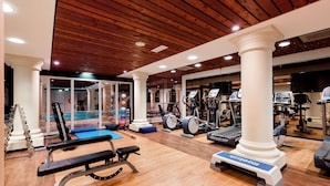 A gym with wooden flooring, exercise equipment, and a pool area. - DoubleTree by Hilton Royal Parc Soestduinen (Soest)
