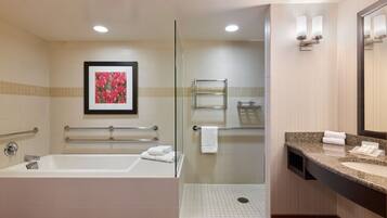 A modern bathroom with a bathtub, shower, and glass-enclosed walk-in shower.