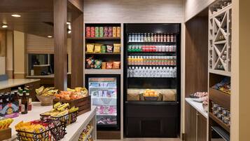 A self-service snack and beverage area with refrigerated and non-refrigerated shelves stocked with various products.