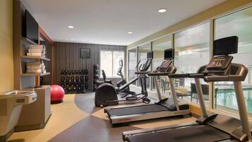 A gym with treadmills, exercise balls, and weight machines.