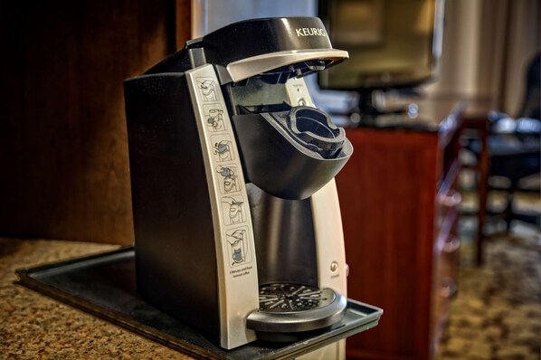 Una cafetera Keurig con un recipiente para goteo y un portacápsulas de café.