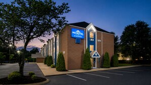 Edificio de Microtel Inn by Wyndham con estacionamiento y árboles.