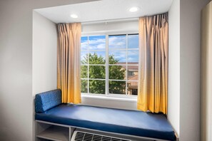 A room with a window, a bench, and curtains. - Microtel Inn by Wyndham Georgetown (Georgetown)