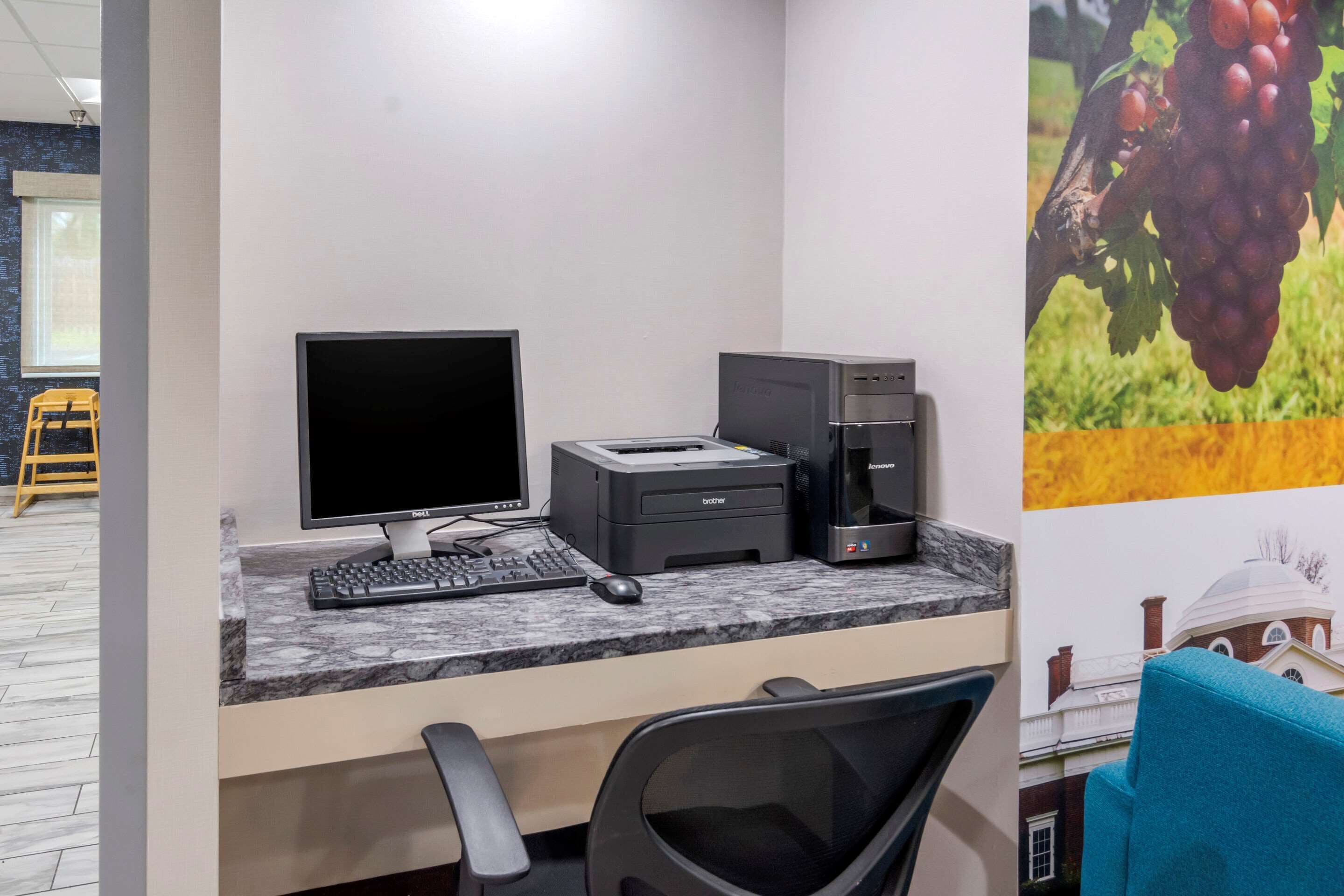A workspace with a desktop computer, printer, and coffee machine.