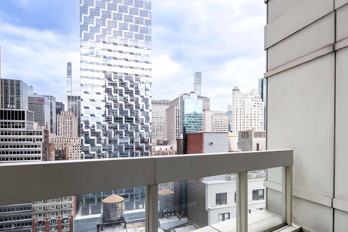 A high-rise building with a distinctive zigzag pattern of windows and a view of the cityscape.