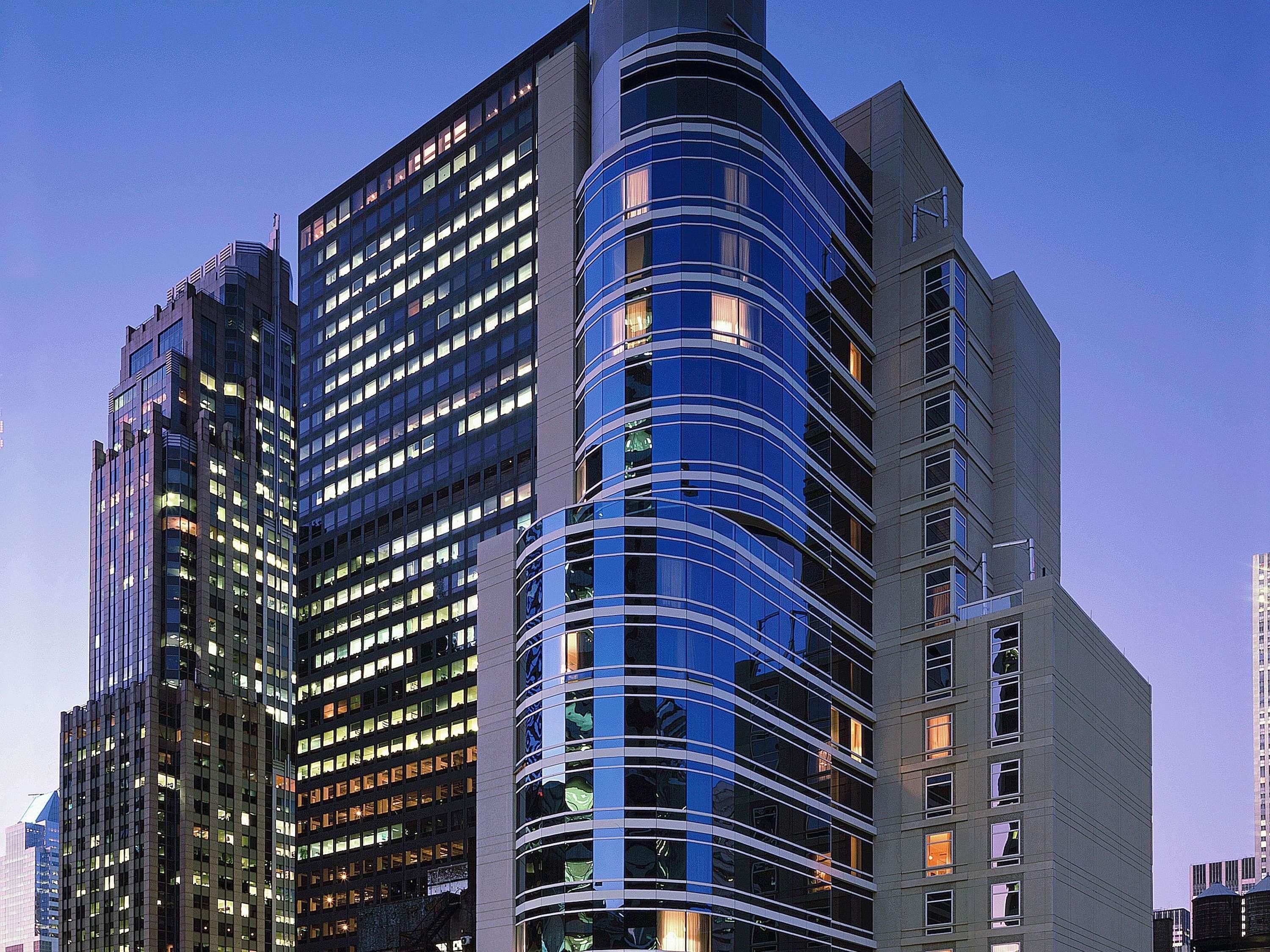 A multi-story building with a curved facade, numerous windows, and a modern architectural design.