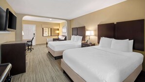 A hotel room with two beds, a desk, a TV, and a seating area. - Best Western Cedar Inn (Cedar Park)