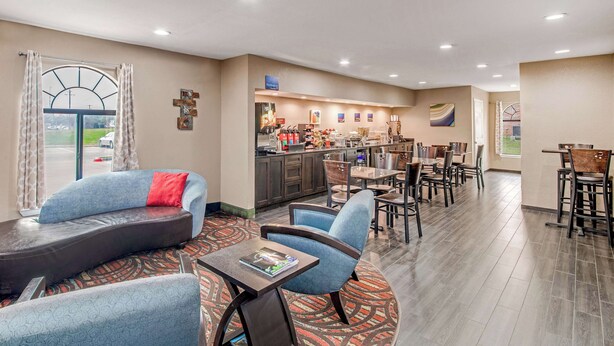 A hotel lobby with a seating area, a bar, and a dining area. - Best Western Cedar Inn (Cedar Park)