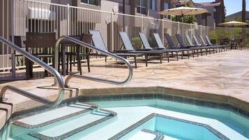 Una piscina al aire libre, sillones reclinables de piscina