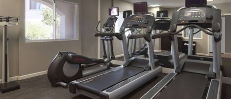 A gym with treadmills, elliptical machines, and a stationary bike.