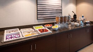 A buffet setup with various food items and condiments.
