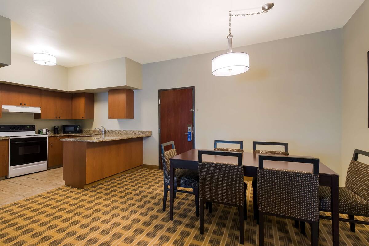 A modern kitchen with a central island, built-in microwave, and stainless steel appliances.