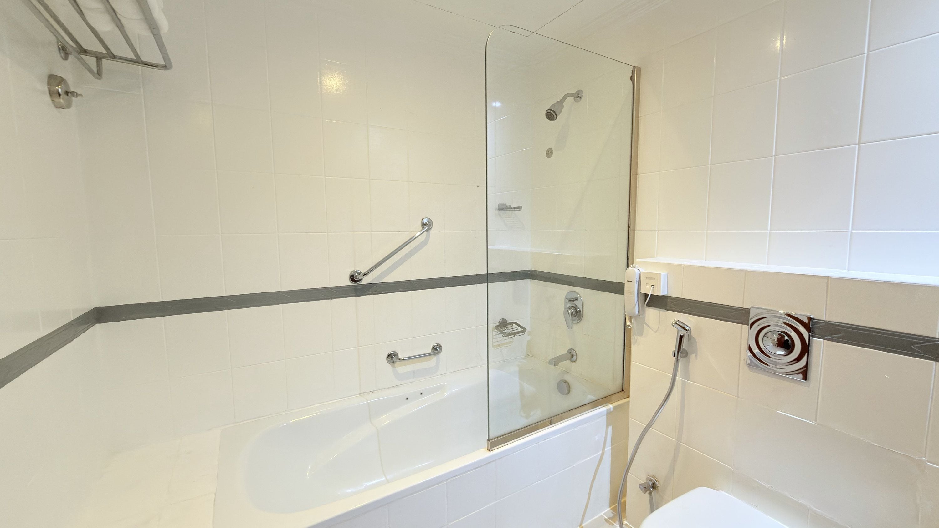 A modern bathroom with a glass-enclosed shower, a bathtub, and a toilet.