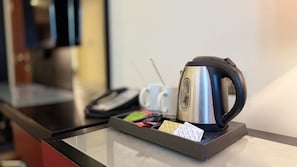 A coffee maker on a table with a tray containing a few items and a cup of coffee. - Excelsior Hotel Downtown (Dubai)