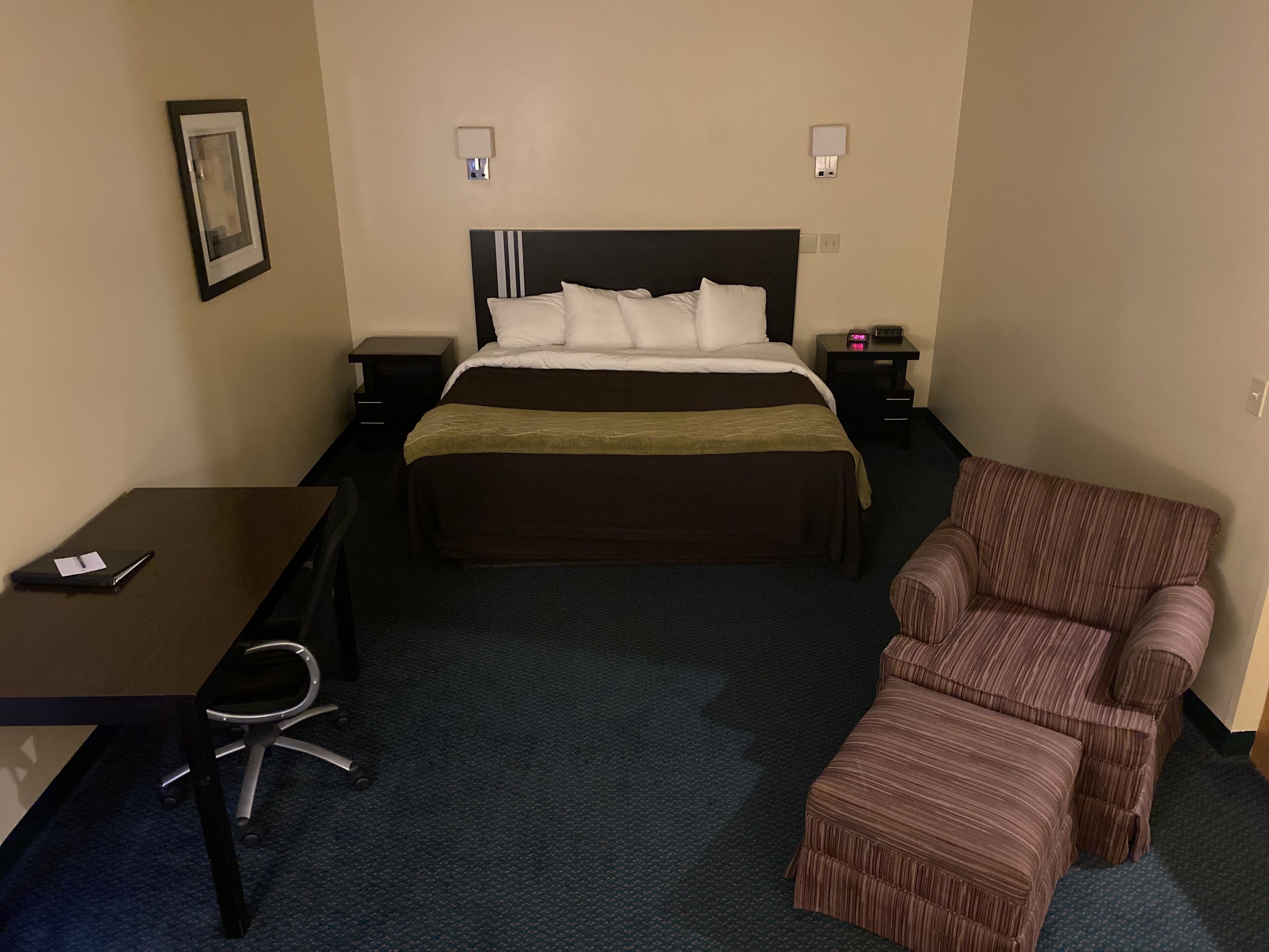 Une chambre d’hôtel avec un lit, un bureau, une chaise et un canapé.