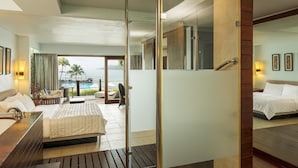Una habitación de hotel con cama, baño y vista al mar.