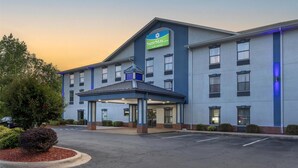 Een SureStay hotel met een overdekte ingang, meerdere ramen en een parkeerplaats.