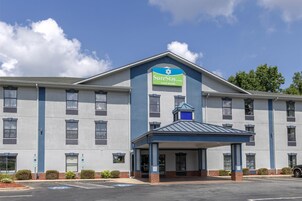 Um hotel SureStay com entrada coberta, várias janelas e estacionamento.