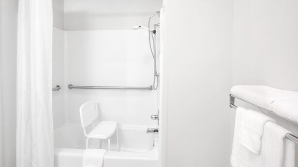 A white bathroom with a shower, a white toilet, and a towel rack. - Super 8 by Wyndham Gas City Marion Area (Gas City)