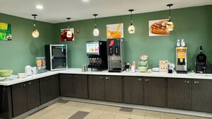 A modern kitchen area with a coffee machine, a refrigerator, and various food items on the counter. - Quality Inn Sulphur - Lake Charles (Sulphur)