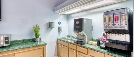 A kitchenette with a coffee machine, a toaster, and a sink.