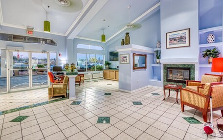 A spacious lobby with a fireplace, comfortable seating, a television, and a view of the outside.