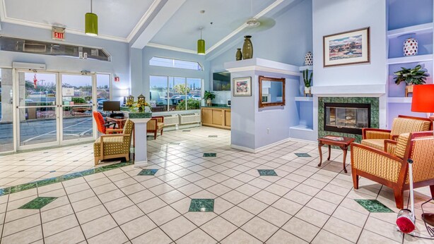 A spacious lobby with a fireplace, comfortable seating, a television, and a view of the outside.