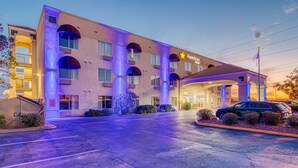 A hotel with a modern design, featuring a central entrance with a covered area and multiple windows.