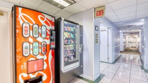 A vending machine with a Coca-Cola logo and a push button.