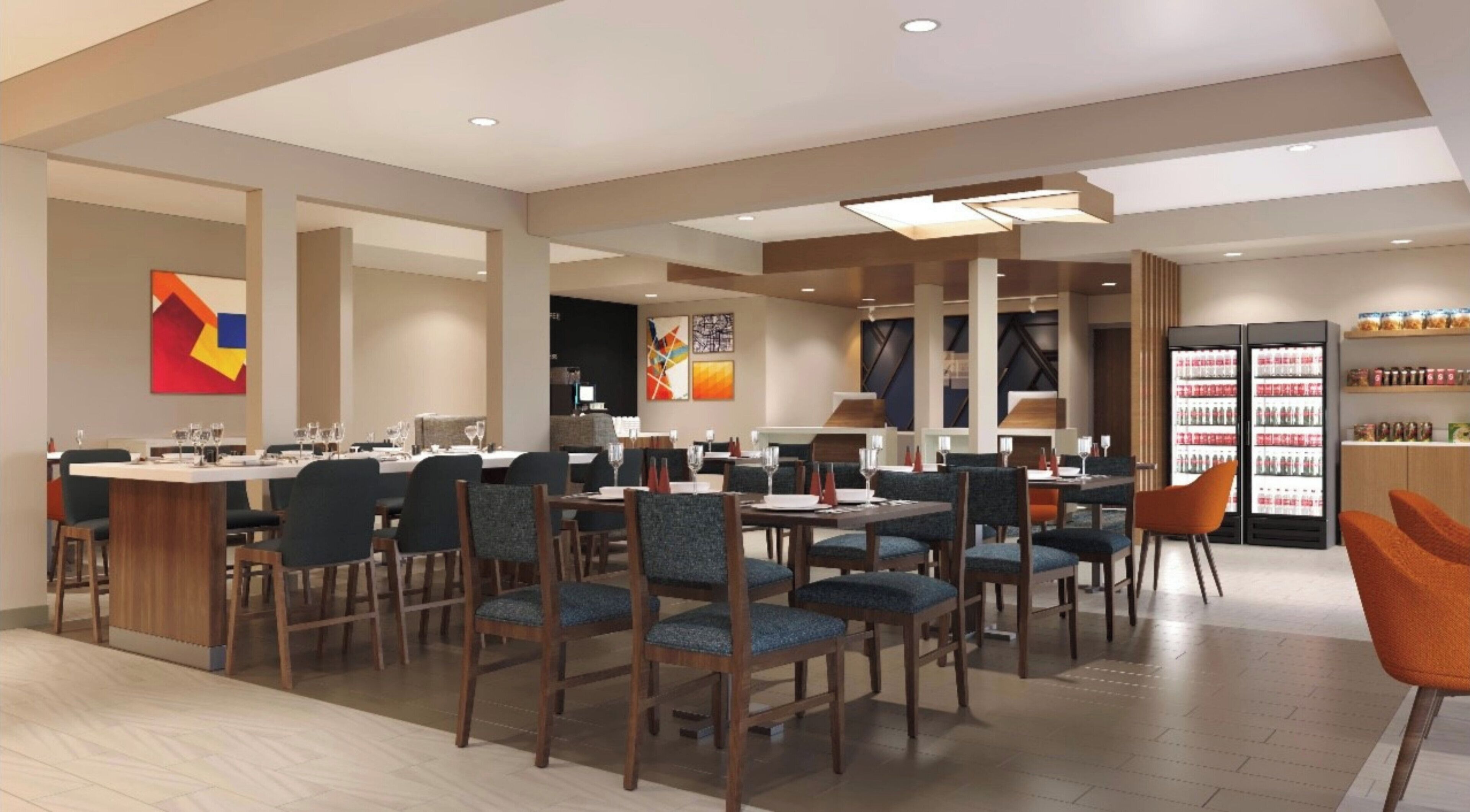 A modern restaurant with multiple dining tables and chairs, a bar area, and a refrigerator stocked with beverages.