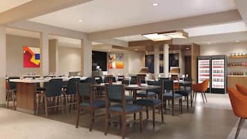 A modern restaurant with multiple dining tables and chairs, a bar area, and a refrigerator stocked with beverages.