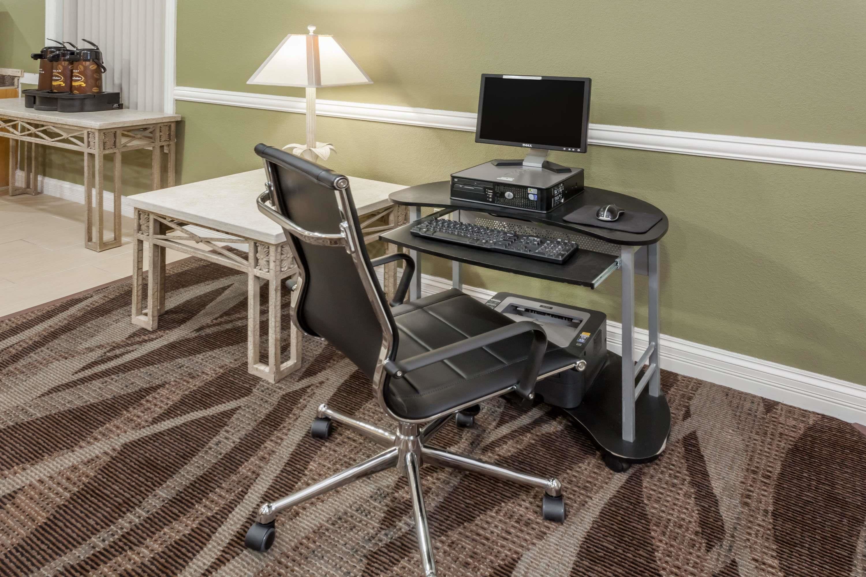 A workspace with a desk, chair, computer, keyboard, and monitor.