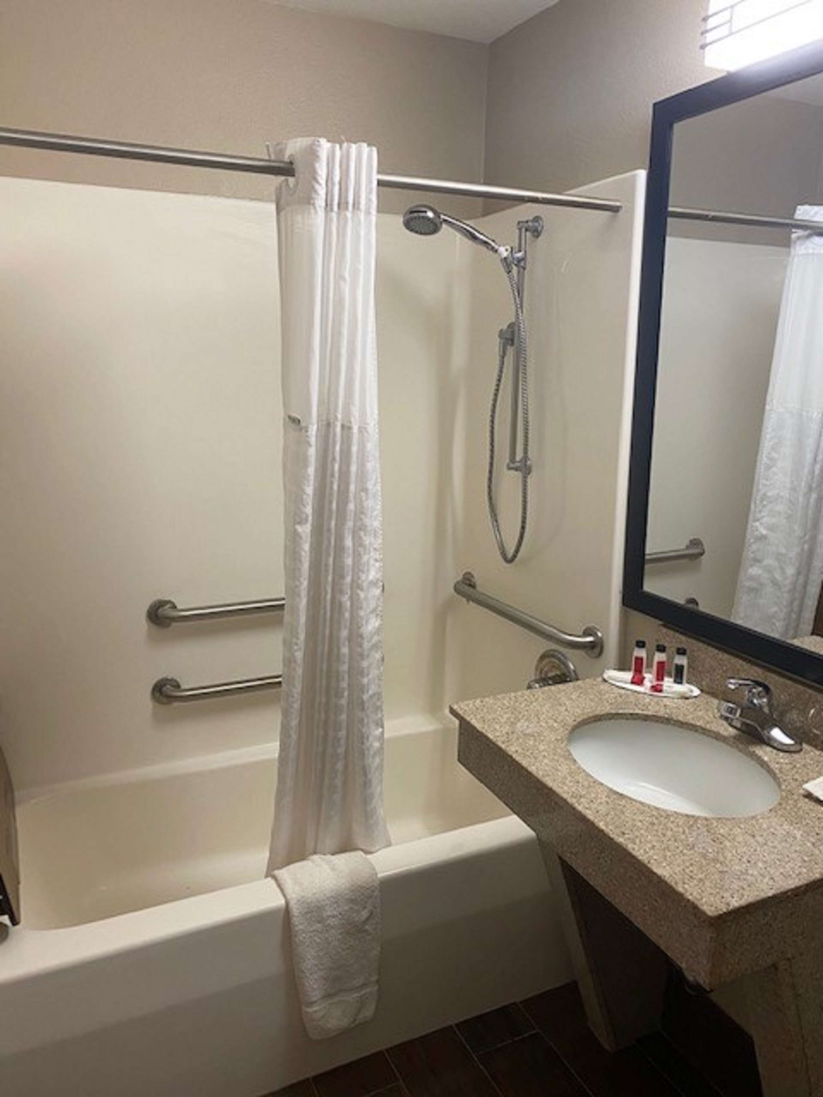 Un baño con bañera, ducha, lavabo y espejo.
