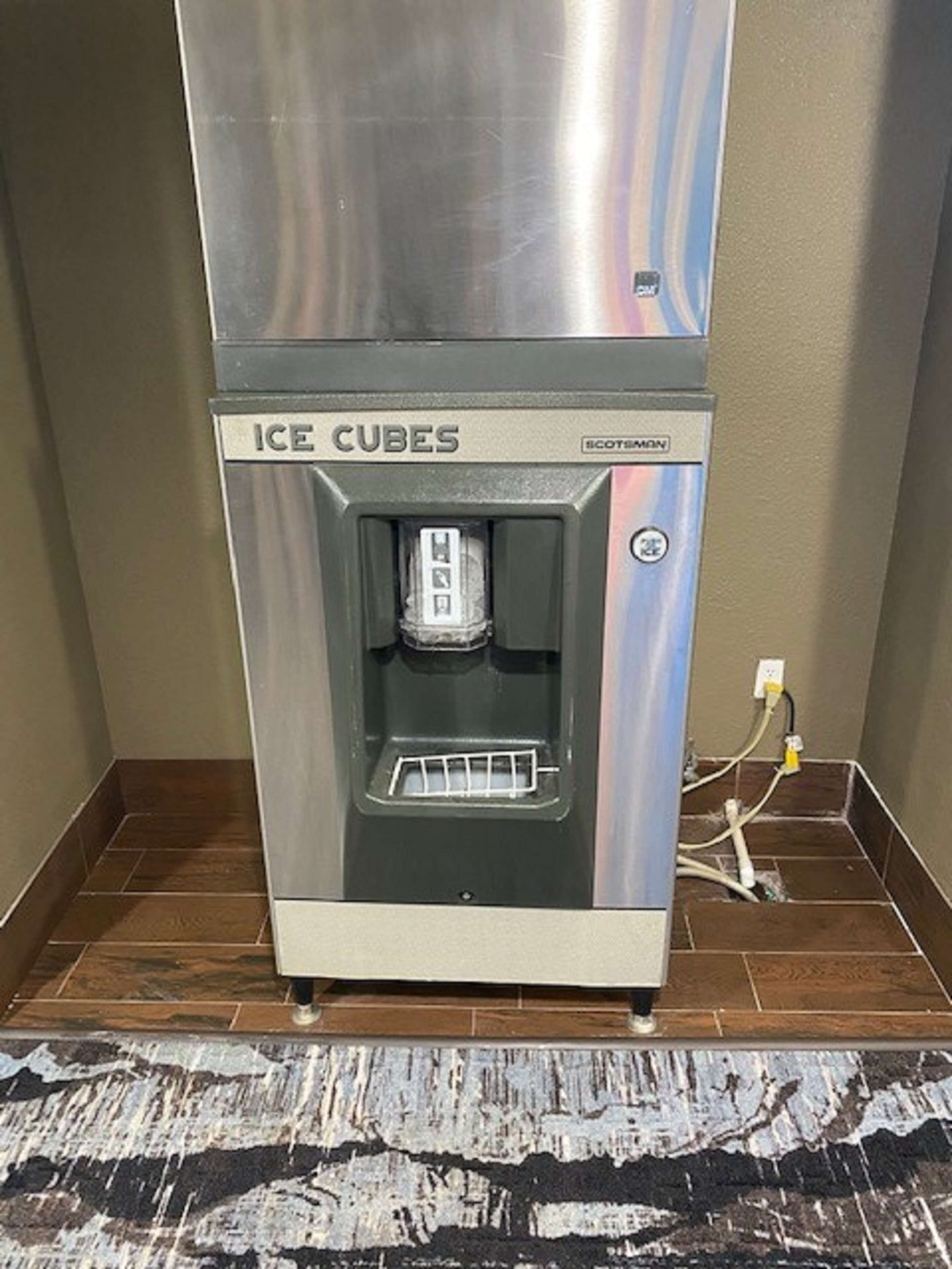 An ice cube dispenser with a stainless steel exterior and a digital display.