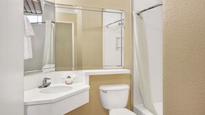 A bathroom with a white sink, mirror, and toilet. - Super 8 by Wyndham Los Angeles Downtown (Los Angeles)