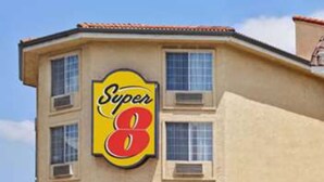 A Super 8 hotel with a prominent sign, multiple windows, and a red roof. - Super 8 by Wyndham Los Angeles Downtown (Los Angeles)