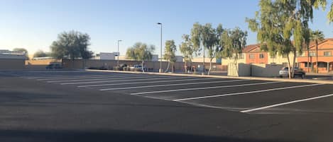 A parking lot with marked spaces and a few vehicles.